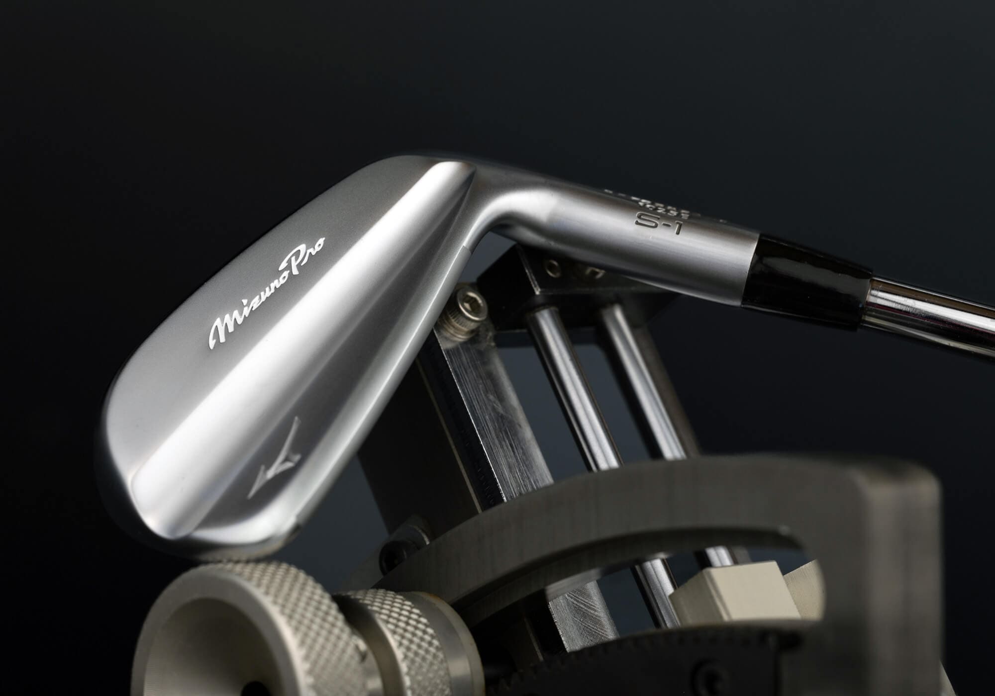 ミズノ「Mizuno Pro S-1」アイアンが測定機にセットされ、バックフェースの精密な仕上げが際立つ。職人技と最新テクノロジーの融合を感じさせるカット。
