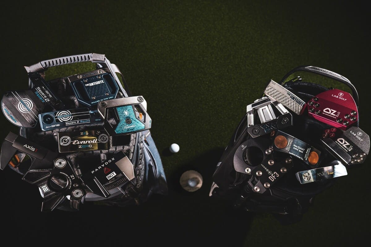 2025年「Most Wanted」ゼロトルクパター全モデルが2つのキャディバッグに収納された写真。L.A.B. GOLF、テーラーメイド、オデッセイ、PXG、ベティナルディ、シーモアなど主要ブランドのパターが並ぶ。中央にはゴルフボールとカップが配置されている。