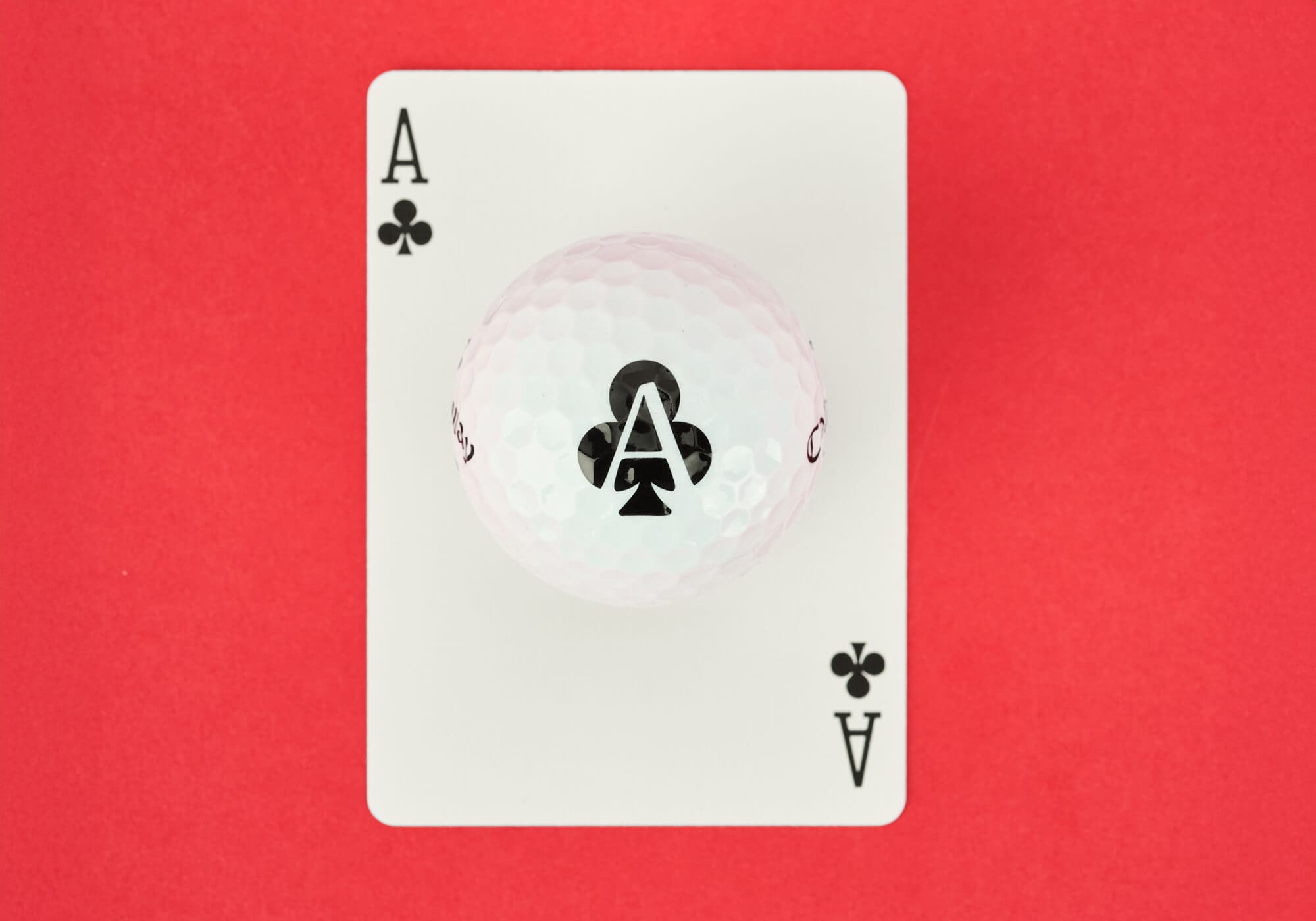 キャロウェイ「Supersoft ACES」クラブ柄のゴルフボール。クローバーのエースカードの上に配置され、ユニークなトランプデザインを強調している。