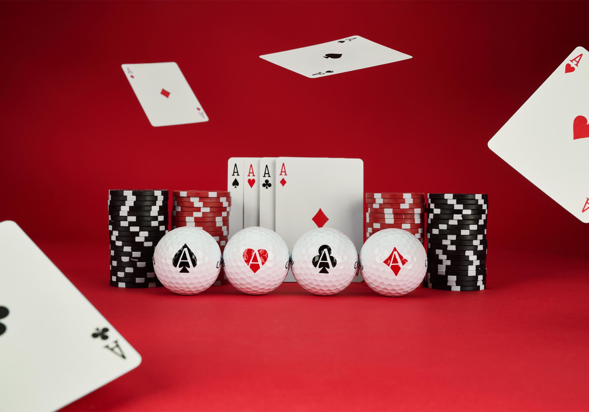 キャロウェイ「Supersoft ACES」ゴルフボール4種。スペード・ハート・クラブ・ダイヤのトランプ柄が描かれ、ポーカーのチップやカードと一緒に並べられている。