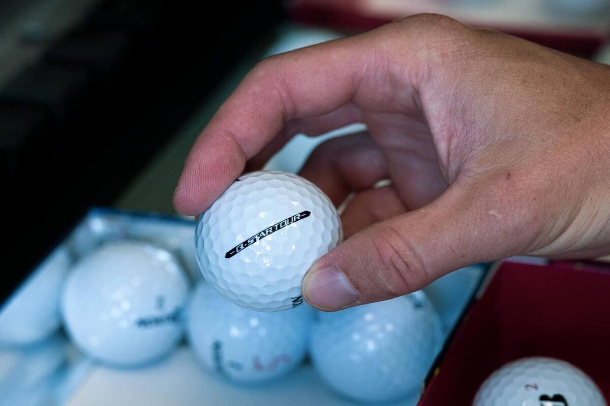2025年ゴルフボールテストで検証用ボールを手に取り、個体差を確認している様子