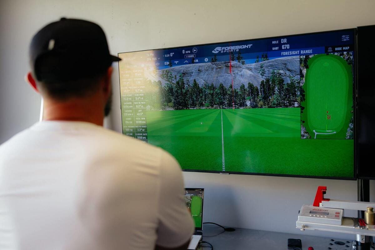 ゴルフボールテストでテスターが弾道シミュレーターの画面を見ながらショットデータを解析している様子