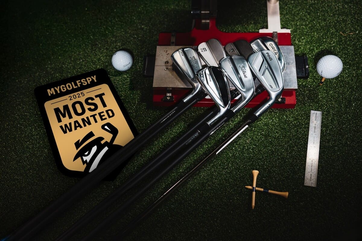 MyGolfSpy 2025年『Most Wanted ドライビングアイアンテスト』で使用されたテスト用アイアンと計測機器。芝の上に並ぶタイトリスト、スリクソン、PING、オルカなどの最新モデル。