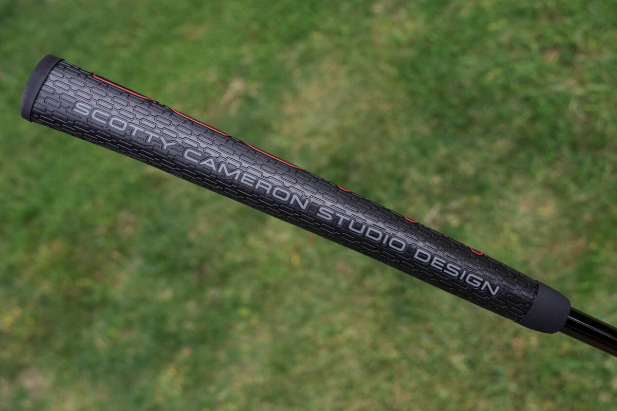 「Fastback OC」パターに装着された黒ベースのStudio Designグリップをアップで撮影。表面パターンとロゴが見える。