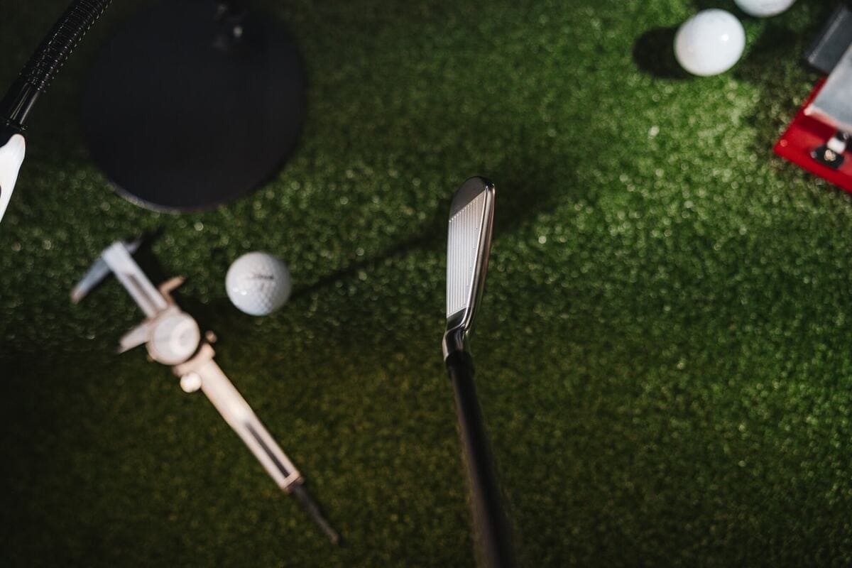 タイトリスト U•505 ドライビングアイアンをアドレスした視点で撮影した写真。人工芝の上にボールや計測機材が並ぶテスト環境。