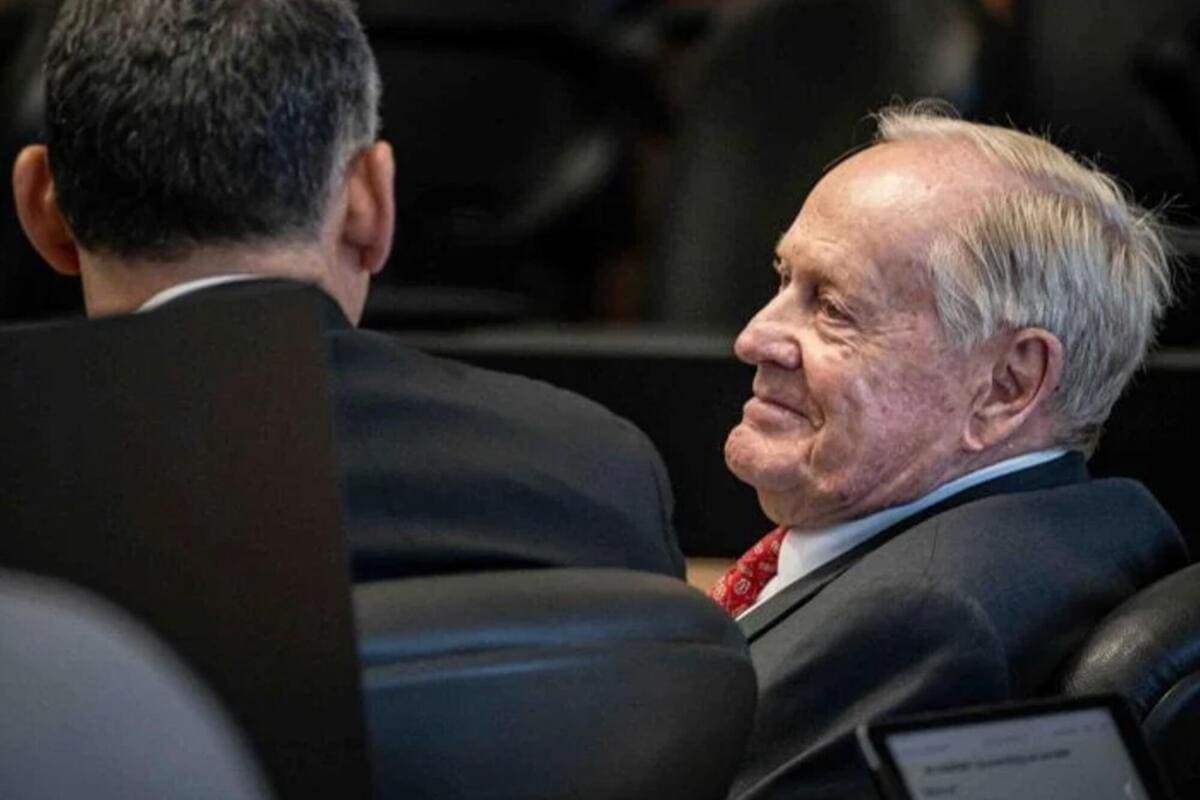 レジェンドゴルファーが裁判所の席で弁護士と並び、穏やかな表情で前方を見つめている様子。