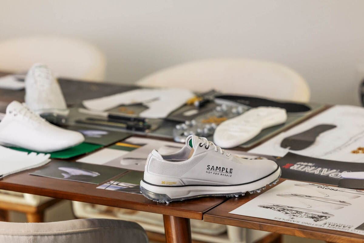 PAYNTR GOLFのデザイン開発現場で、ジェイソン・デイがゴルフシューズの設計資料を確認している様子