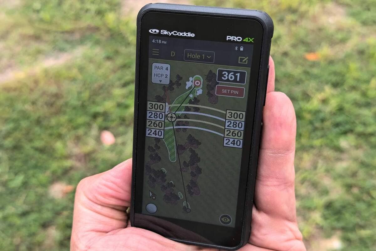 SkyCaddie PRO 4X を手に持ち、フェアウェイの形状や距離情報を詳細に表示している画面を撮影した写真。大画面でのコース攻略イメージ。