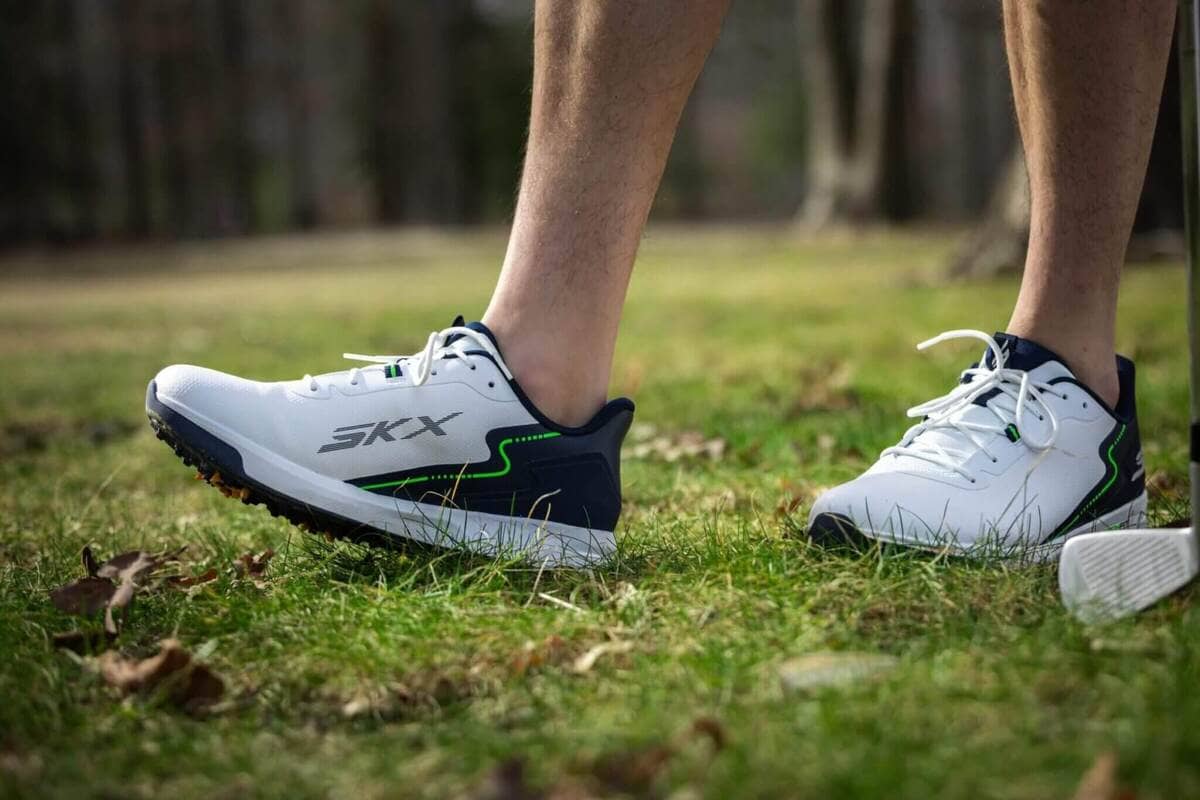 スケッチャーズのゴルフシューズを着用したアドレスシーン。芝生の上で安定した足元を支える様子