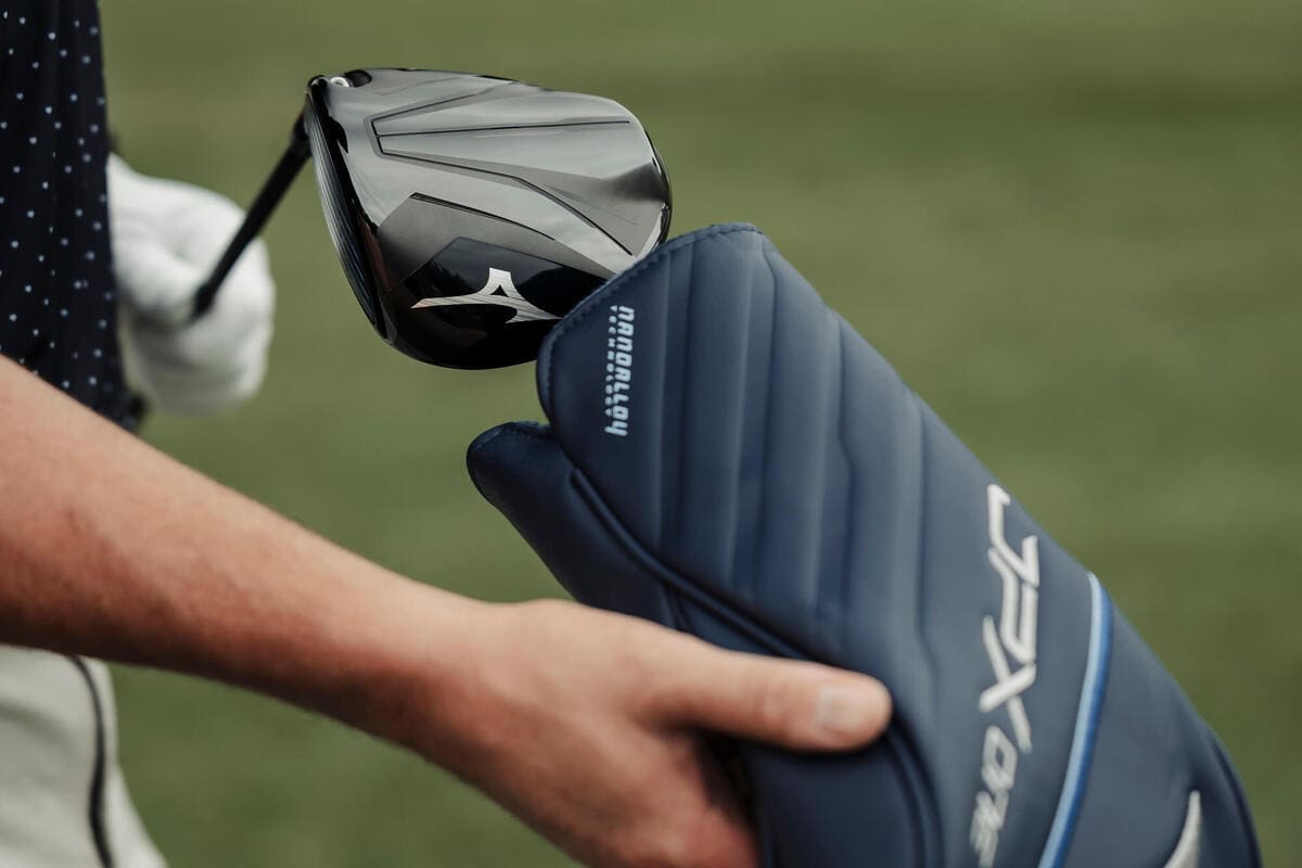 ミズノ「JPX ONE」ドライバーに専用ヘッドカバーを装着するシーン。光沢感のあるクラウンデザインが特徴。