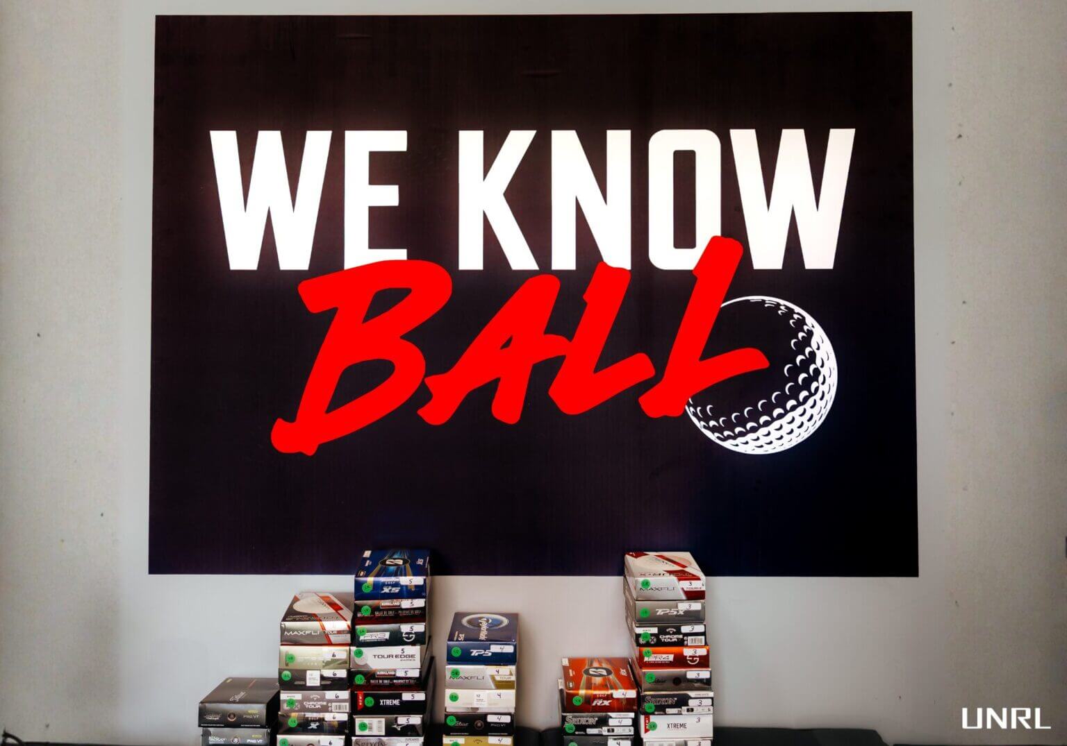 「WE KNOW BALL」のサインの下に並べられた2026年ゴルフボールテスト対象製品