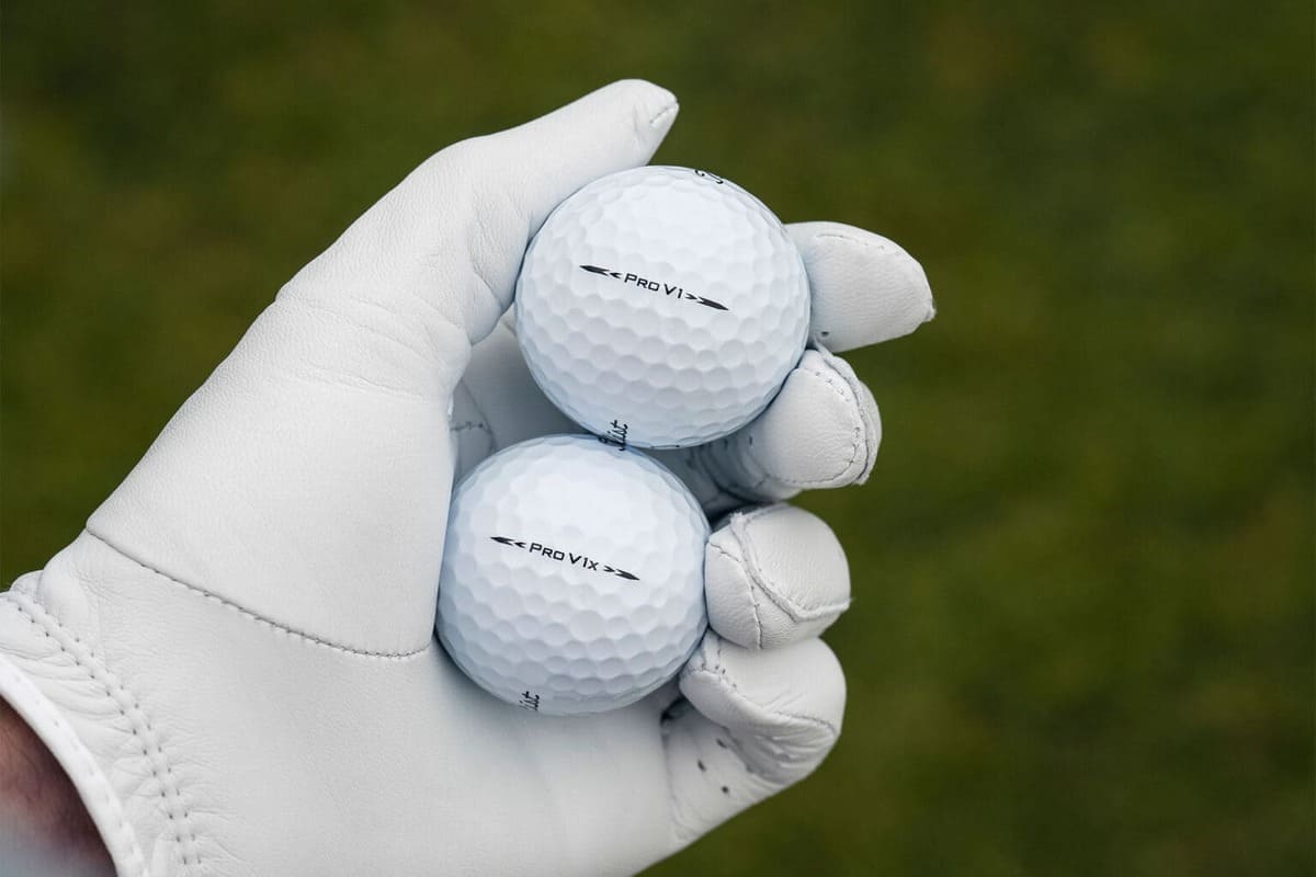 ゴルフグローブを着けた手に持つ2027年モデルのタイトリスト「Pro V1」と「Pro V1x」