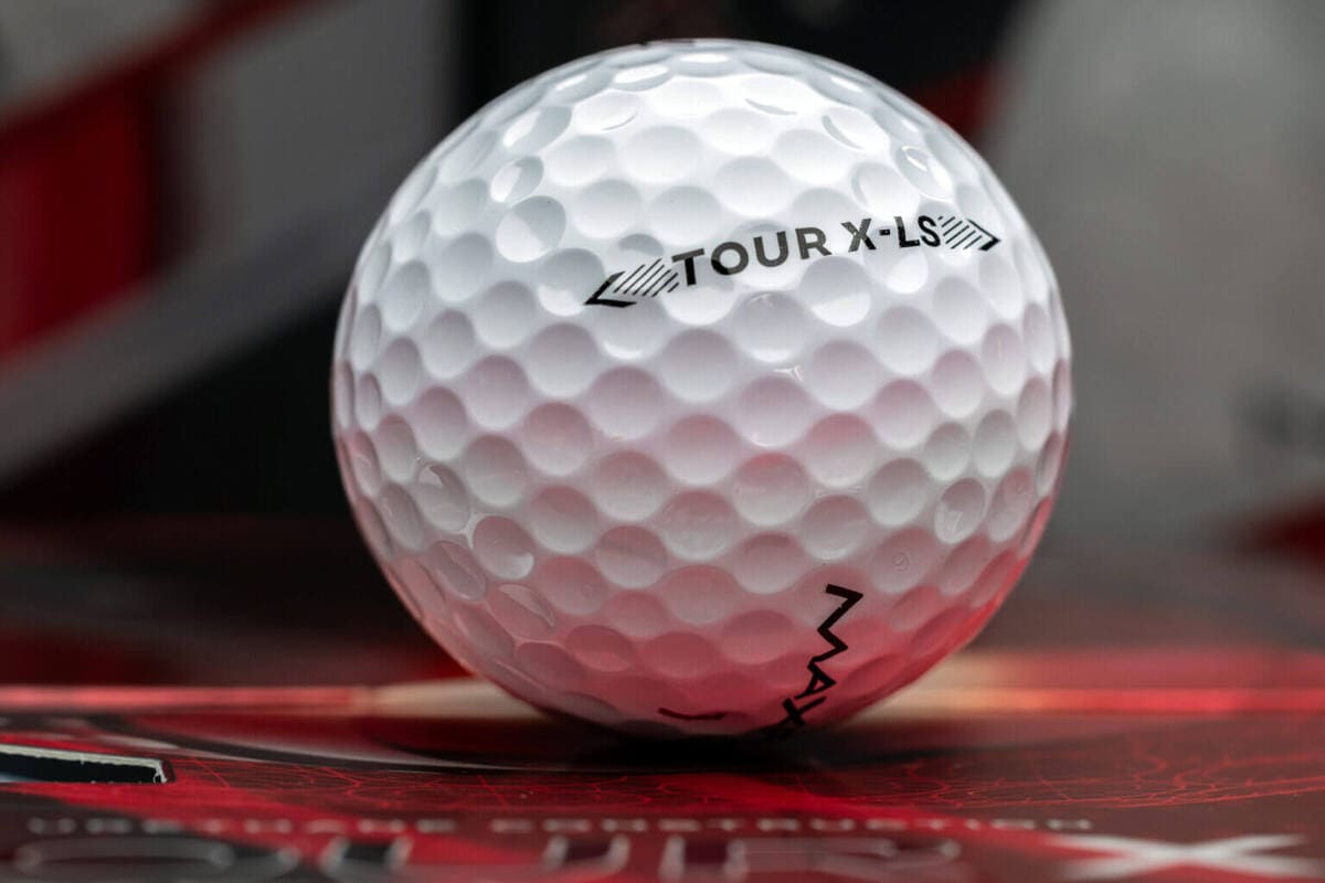 MAXFLI TOUR X-LSのロゴが印字された白いゴルフボールのクローズアップ。
